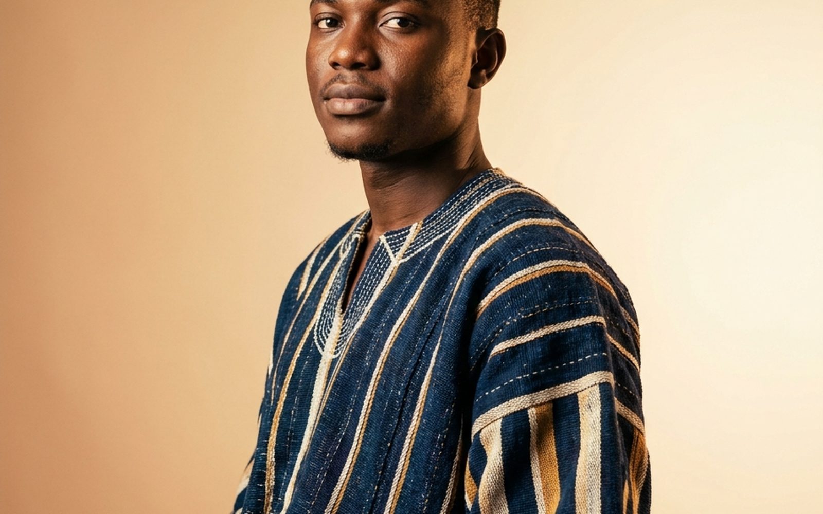 A man wearing an authentic hand-woven indigo and ochre Ghana fugu smock